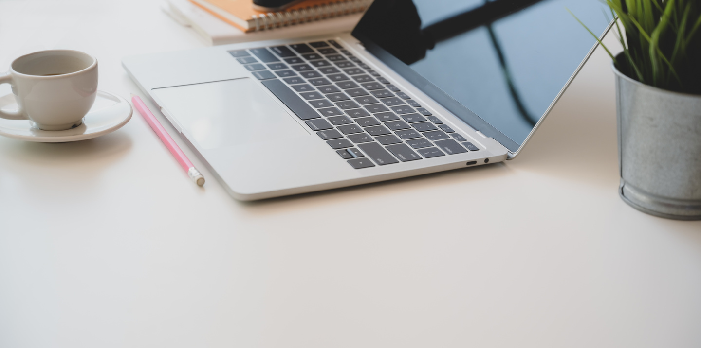 Laptop and cup of coffee on table